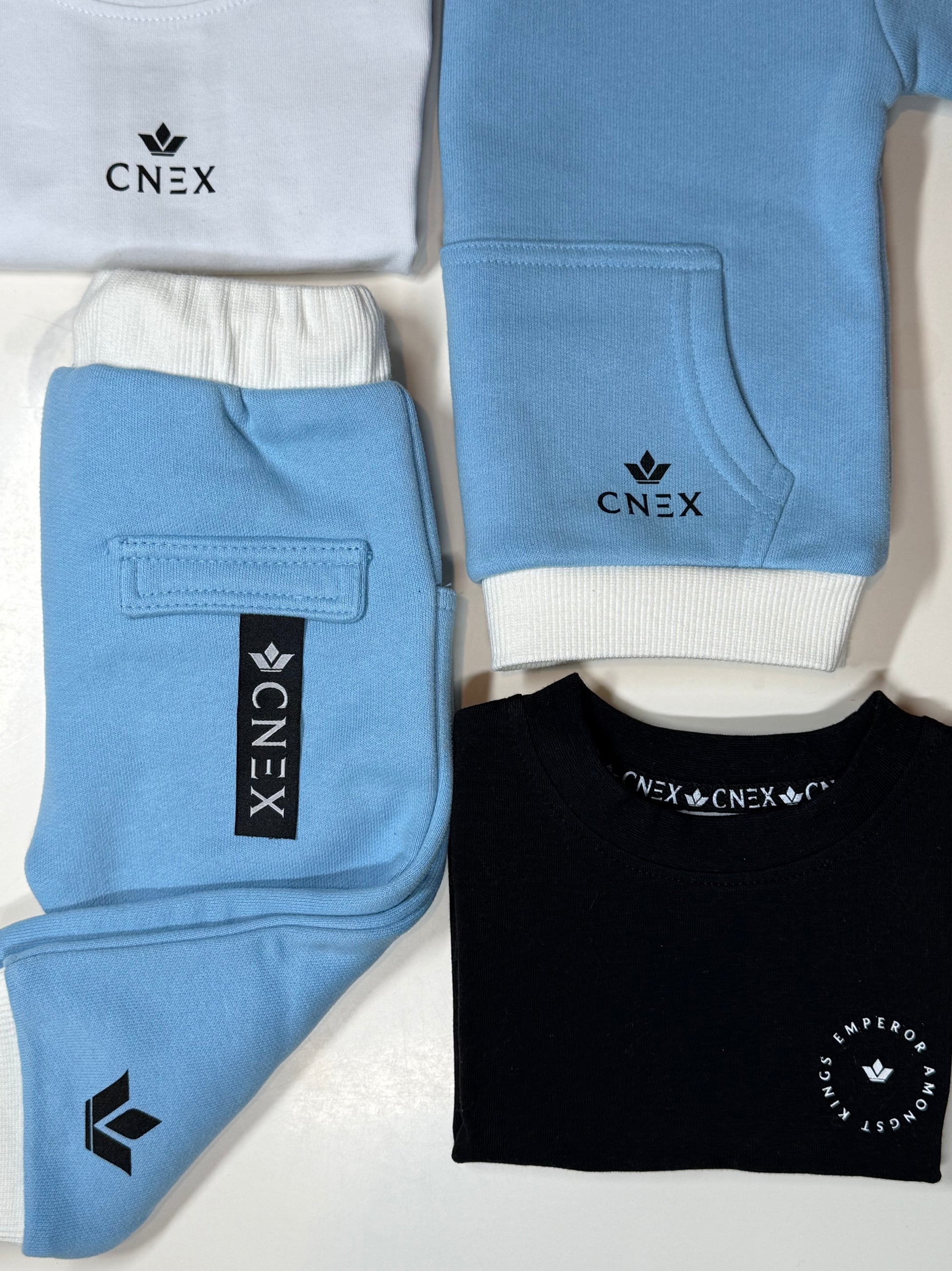Folded blue and black clothing items with CNEX branding on a white background